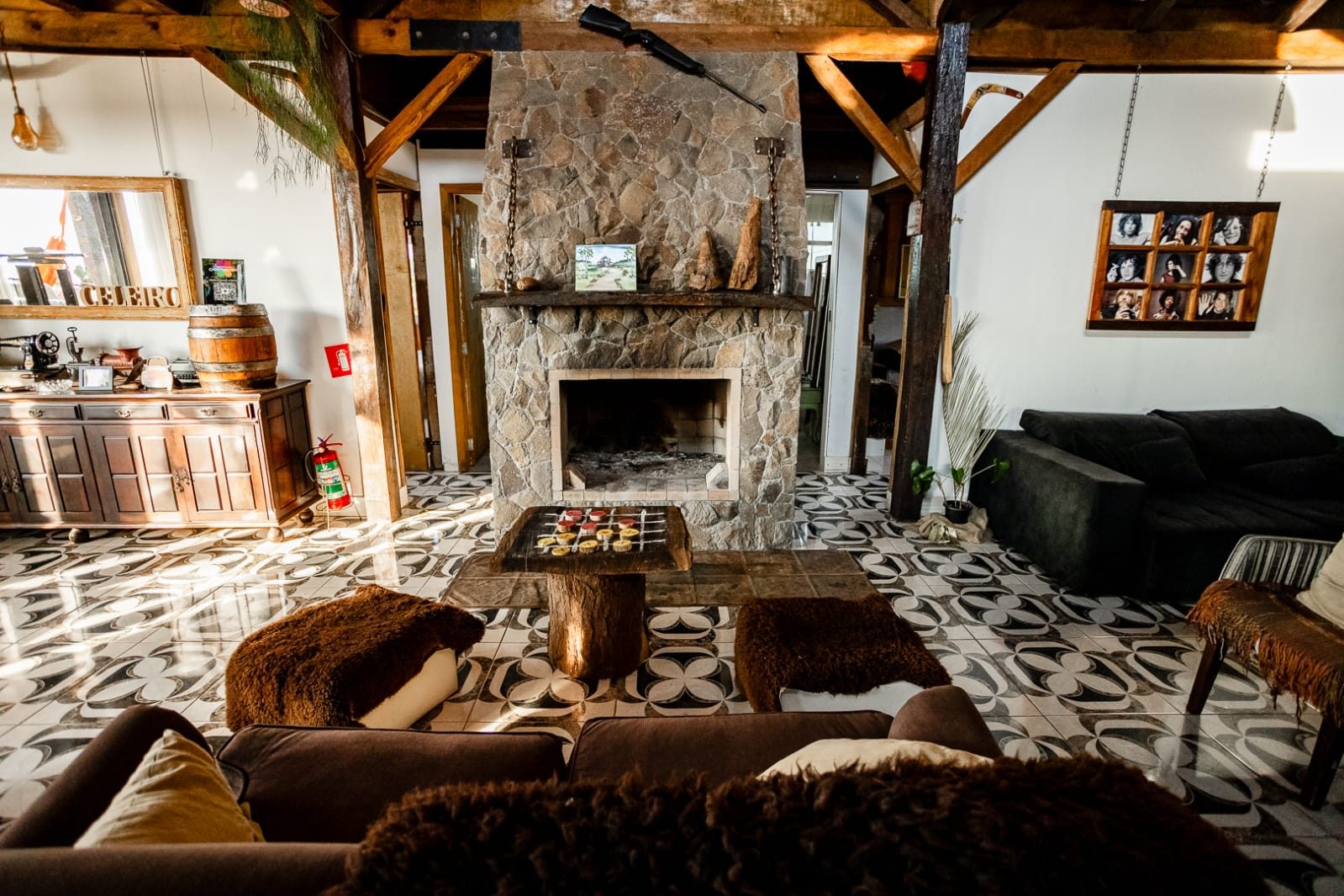 Sala de estar do Celeiro com lareira de pedra e sofás confortáveis