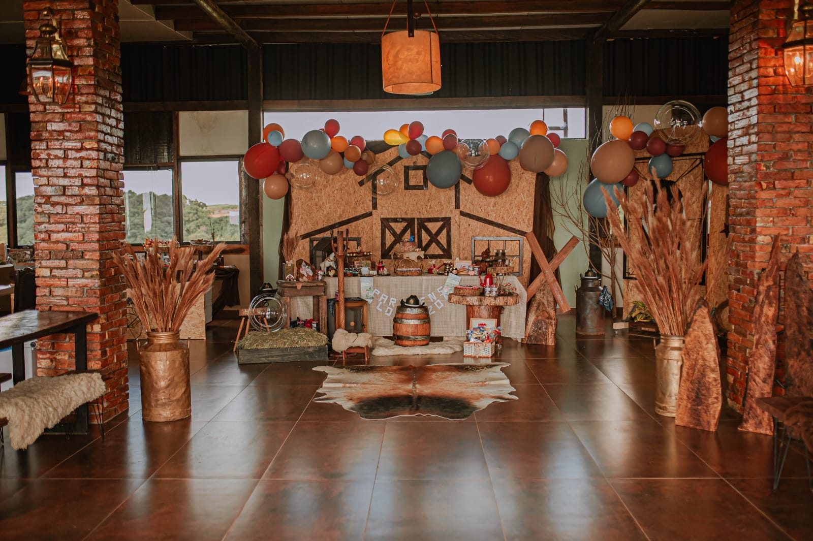 Interior do salão de eventos do Celeiro com pé-direito alto e piso de madeira