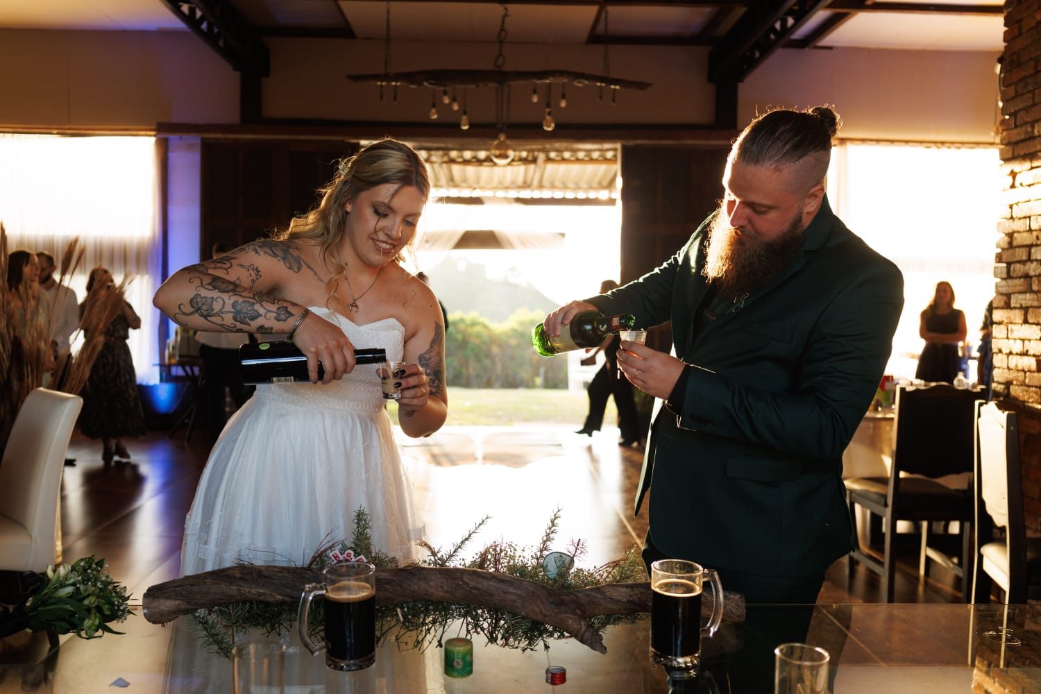 Noivos cortando o bolo durante a festa de casamento no salão do Celeiro