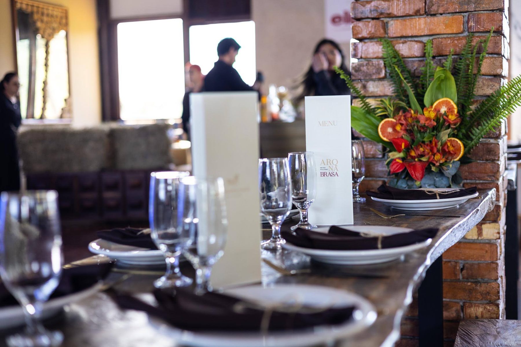 Mesa posta elegante com taças e flores para jantar no Celeiro