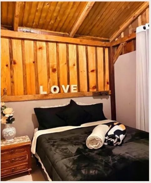 Detalhe do quarto Alaska com painel de madeira e toalhas preparadas