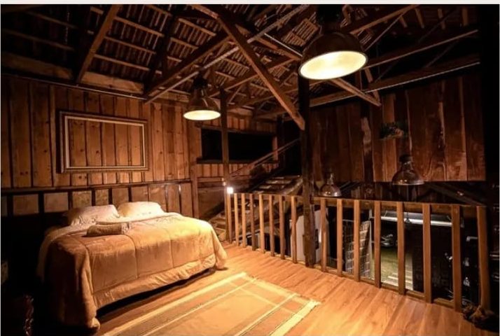 Quarto Scotland no mezanino do Celeiro, com cama queen e teto de madeira