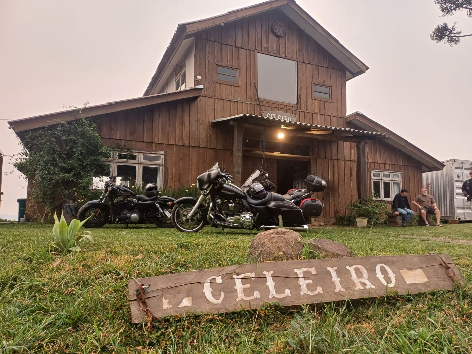 Fachada do Celeiro Guarapuava com placa de madeira no gramado