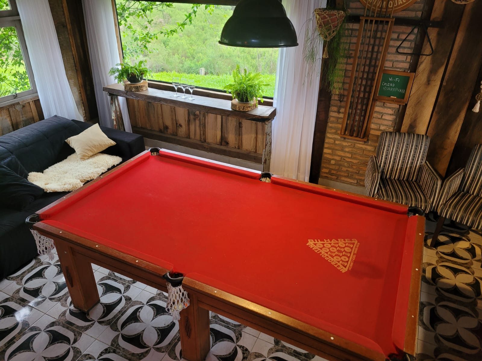 Mesa de sinuca vermelha na área de convivência do Celeiro
